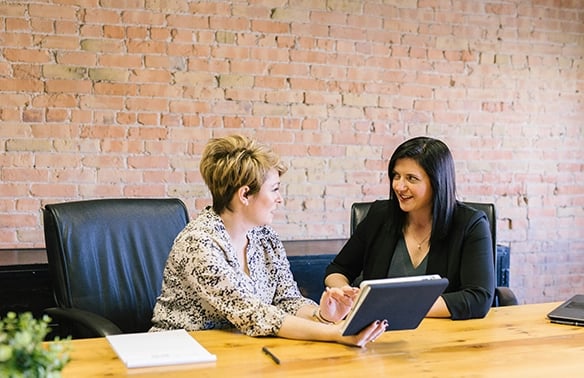 Women Staff members talking about duties in a meeting room